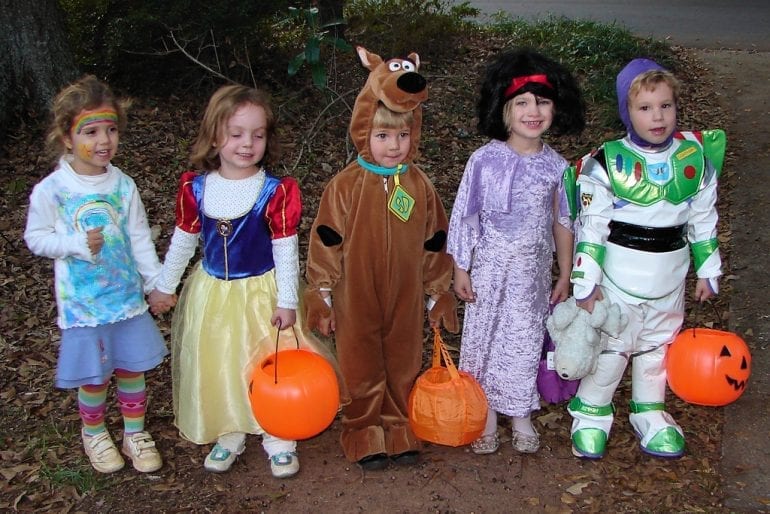 Crianças E Pais No Halloween Gostosuras Ou Travessuras. Família Em Trajes  De Halloween Com Sacos De Doces Andando Na Rua Decorada Doces Ou  Travessuras. Bebê E Pré-escola Comemorando O Carnaval. Fantasia De